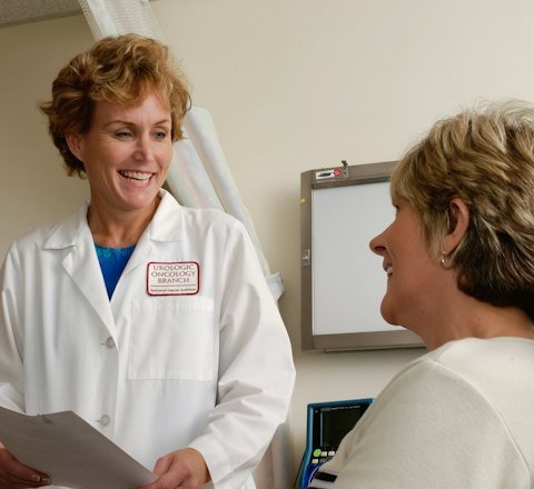 A smiling doctor talking with a patient in a clinic