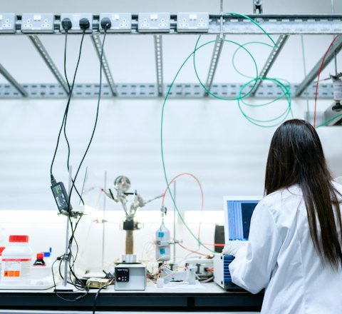 A scientist in a lab coat working at a laboratory bench