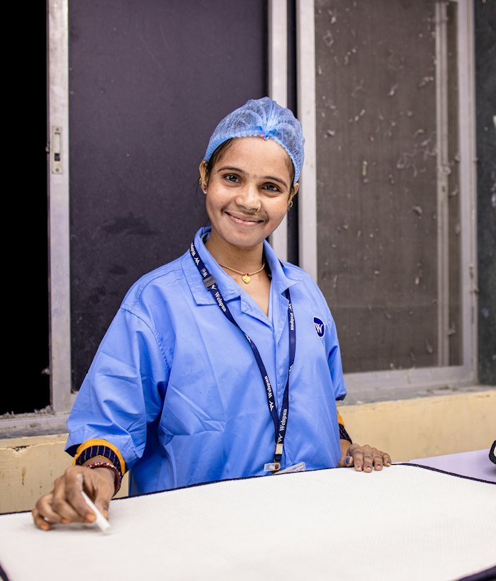 A smiling healthcare worker in a surgical cap and scrubs