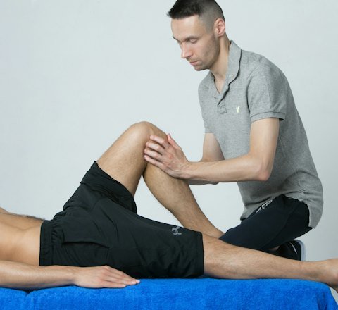 A therapist examining a patient's knee